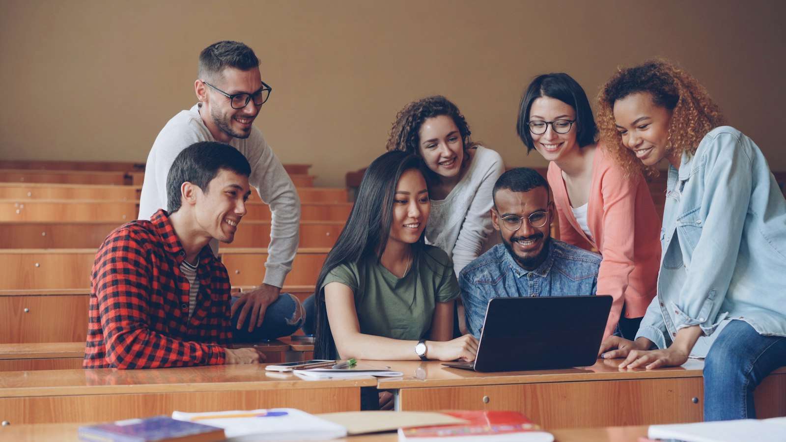 Des participants réunis autour d'un ordinateur, qui échangent et apprennent ensemble
